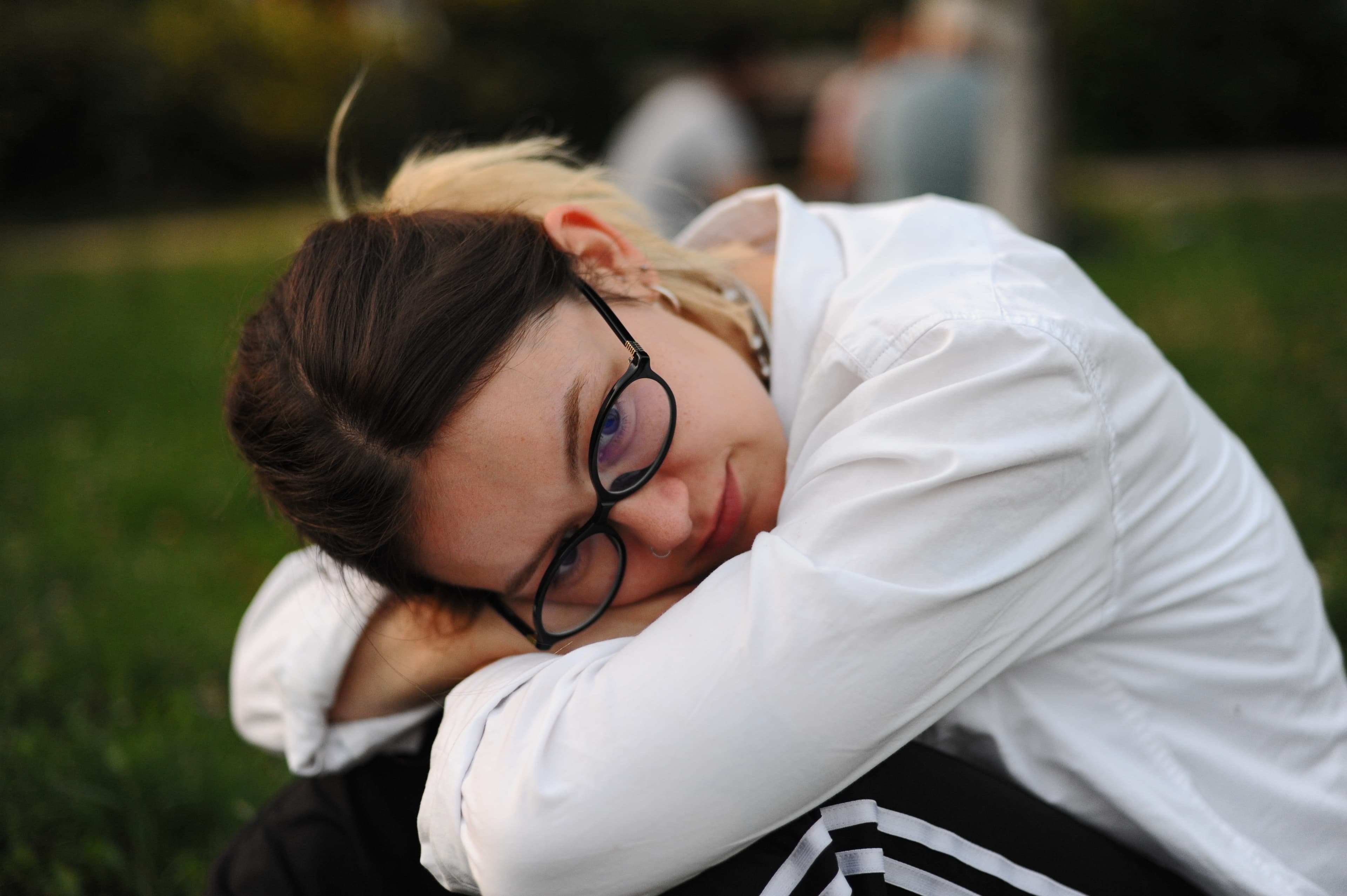 Nahes Porträt einer Person, die ihren Kopf auf den Armen ablegt